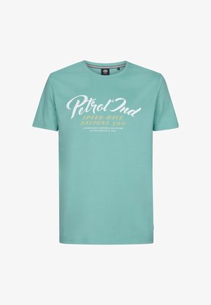 Light teal cotton t-shirt with crew neckline. White and gold printed text displaying 'Petrol Ind' and 'Speed Race Daytona 500.' Short sleeves.