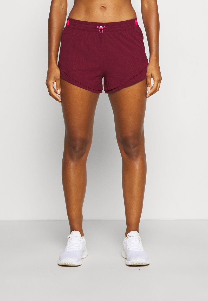 Pantalones cortos deportivos burdeos con cintura ajustable y acentos en rosa, que presentan un diseño en capas y un tejido transpirable para mayor comodidad.