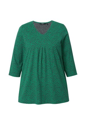 Tunic verde con scollo a V, maniche a tre quarti e fronte plissettata. Presenta un motivo testurizzato di piccole foglie verde scuro.
