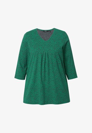 Tunic verde con scollo a V, maniche a tre quarti e fronte plissettata. Presenta un motivo testurizzato di piccole foglie verde scuro.