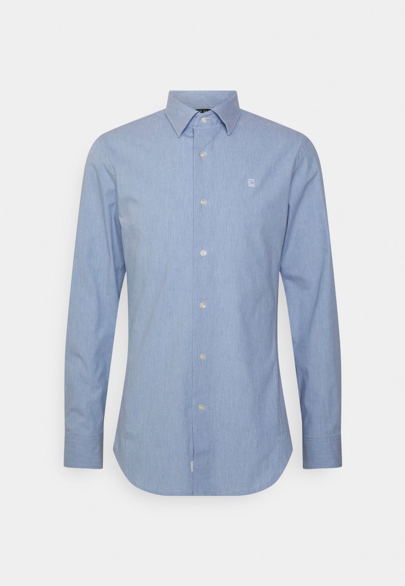 Chemise habillée pour homme à manches longues bleu clair, avec fermeture à boutons, col pointu et petit logo blanc sur la poitrine gauche.