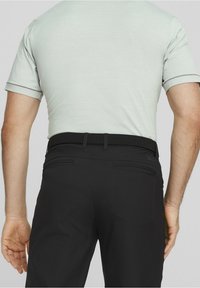Chemise gris clair à manches courtes avec une texture subtile, associée à un pantalon noir doté d'une ceinture tressée et de deux poches arrière.