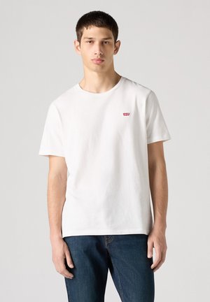Vit bomullströja med rund hals, korta ärmar och ett litet rött Levi's-logotypmärke på vänster bröst.