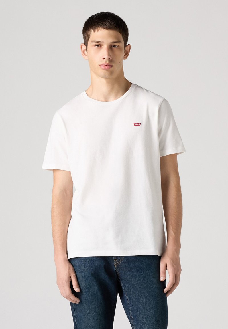 Witte katoenen t-shirt met een ronde hals, korte mouwen en een klein rood Levi's logo patch op de linkerborst.