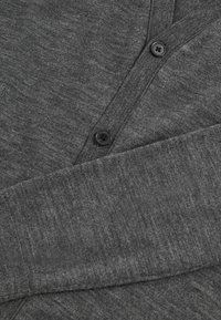 Gray cardigan with a textured knit, featuring a v-neck, three black buttons down the front, and cuffed sleeves.