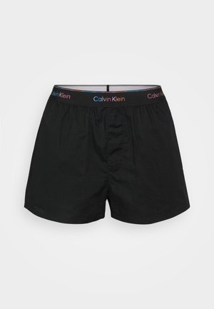 Black cotton boxer shorts featuring an elastic waistband with multicolored "Calvin Klein" branding and a front opening.