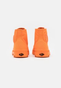 Botines de lona naranjas hasta el tobillo con una suela texturizada, punta redondeada y un parche de logo redondo en el lado exterior, que presentan un diseño suave y elegante.