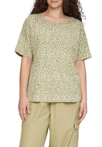 Koszulka z krótkim rękawem, w jasnym oliwkowym odcieniu z białym wzorem w kropki, okrągły dekolt, luźny krój, wykonana z lekkiego materiału, odpowiednia do codziennego noszenia.