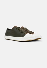 Mørkegrønne lædersneakers med en hvid gummitip og sål. Har brune snørebånd og en subtil tekstur på det øverste materiale.