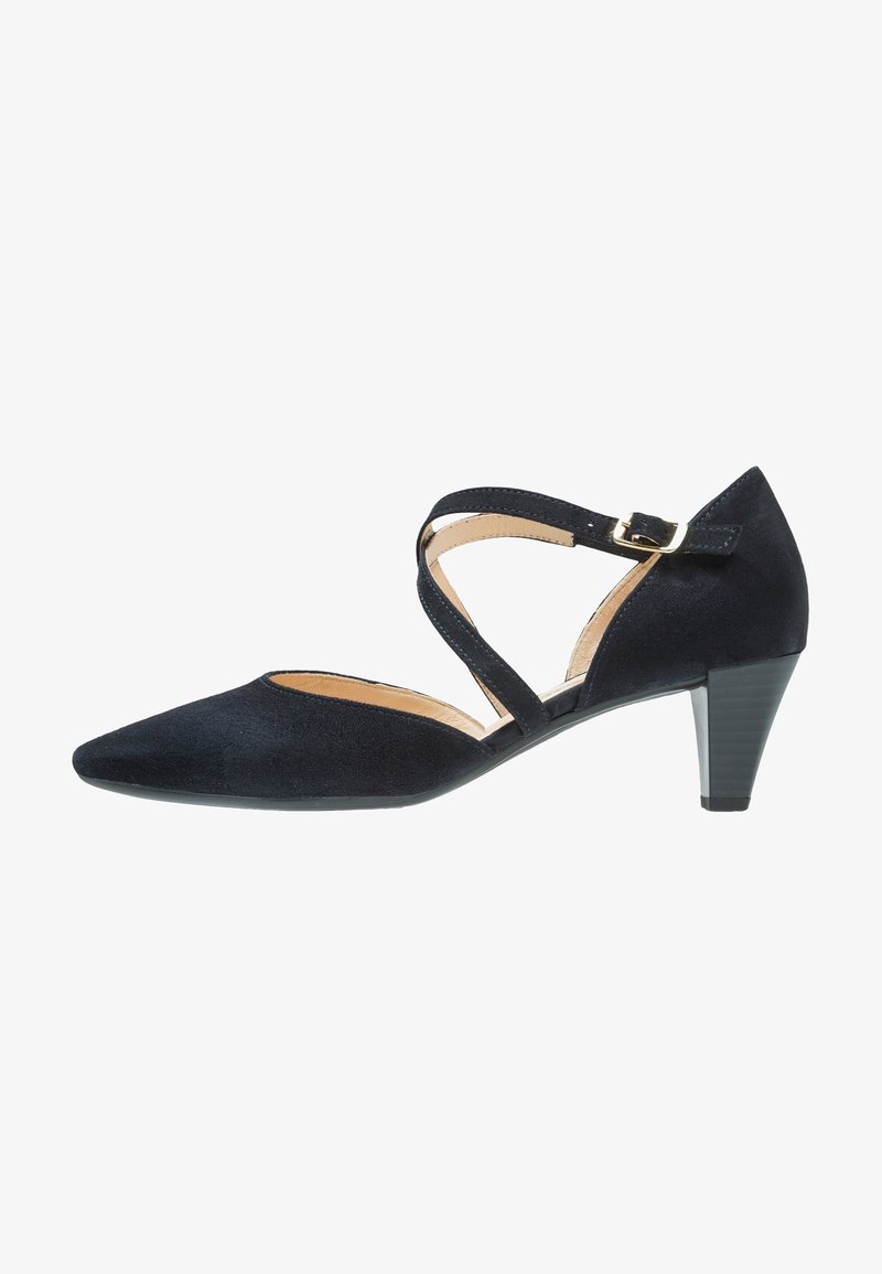 Chaussure basse pour femme en suède noir avec pointe pointue et lanières croisées à la cheville avec boucle dorée.