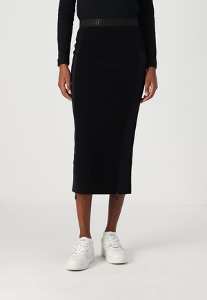 Jupe midi noire en tissu extensible, avec une taille élastique à motifs, des zips sur les côtés et une silhouette ajustée.