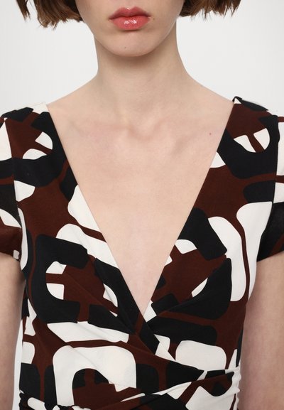 Vestido con un estampado marrón, negro y blanco, con un profundo escote en V y mangas cortas. La tela parece suave con un ligero brillo.