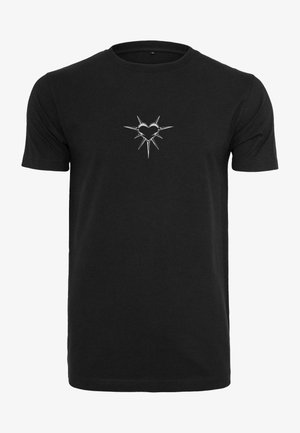 T-shirt en coton noir avec un motif de cœur argenté entouré de picots sur la poitrine. Manches courtes et style col rond classique.