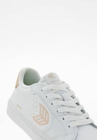 Białe sneakersy z teksturowanej skórzanej cholewki, beżowymi akcentami, okrągłymi sznurowadłami i gumową podeszwą. Posiadają wytłoczone logo oraz starannie wykończone szwy.