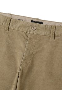 Pantaloni in velluto a coste color khaki con una texture morbida, caratterizzati da una chiusura a bottone e una zip frontale. Presentano passanti per cintura e una sottile costinatura verticale.