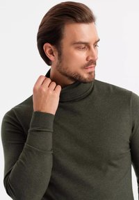Pull à col roulé de couleur vert foncé en maille fine, avec des manches ajustées et un col haut. Texture lisse, détails minimaux.