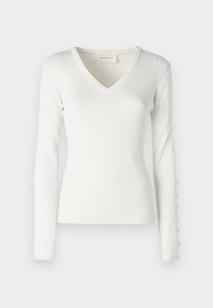 Balta ribota garām piedurknēm augša ar V veida kakla izgriezumu un pogu oranžēšanas detaļām pa piedurknēm. Mīksts audums ar pieguļošu formu.