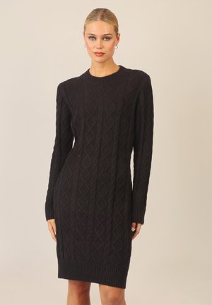 Schwarzes Strickkleid mit einem Rautenmuster, langen Ärmeln und einem gerippten Saum. Weiche Textur mit einer figurbetonten Silhouette.