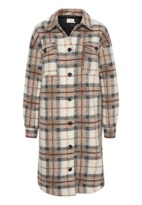 Chaqueta de camisa a cuadros en tonos crema, marrón y gris. Presenta un cuello, mangas largas y botones negros en el frente. Tejido suave y texturizado.