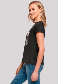 Black short-sleeve t-shirt featuring a skeleton graphic in a central design. Constructed from a soft, lightweight fabric.