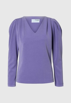 Vaatteet pitkähihaista violettia ykköstä, jossa on V-aukko, puffihihat ja pehmeä rakenne. Valmistettu kevyestä, joustavasta kankaasta.