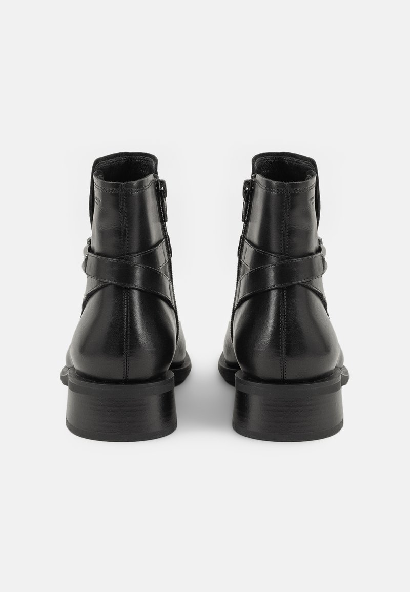 Czarne skórzane botki za kostkę o gładkiej fakturze, z bocznym zapięciem na zamek oraz krzyżującymi się paskami, na masywnej podeszwie.