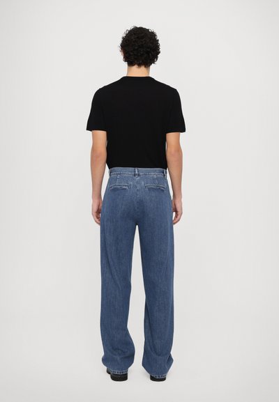 Blue denim jeans with a relaxed fit, high waist, and straight legs. Features two rear pockets and a button closure. Paired with a black shirt.