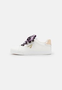 Sneaker bianco con tomaia texturizzata, lacci in satin viola e nero, un accento sul tallone di colore rosa chiaro e un logo dorato di lato.