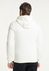 Sweat à capuche blanc avec cordon de serrage, poignets et ceinture ajustés. Texture lisse, design uni, sans motifs ni éléments visibles.