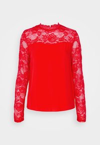 Blusa rossa a maniche lunghe con sovrapposizione in pizzo floreale sulle maniche, sulla parte superiore del petto e sul colletto, caratterizzata da un collo alto e un corpo in tessuto uniforme.