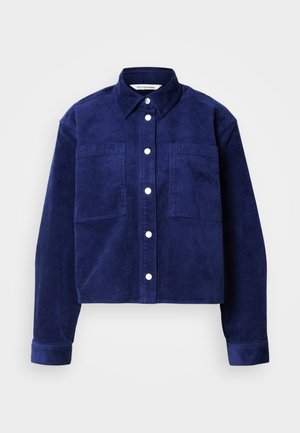 Námořnická kordurová košile s bundou, dvě přední kapsy, zapínání na knoflíky vpředu, límec a dlouhé rukávy s knoflíkovými manžetami.