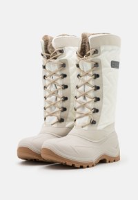 White snow boots with textured fabric upper, beige accents, and brown rubber outsole. Features quilted design and lace-up front for adjustable fit.
