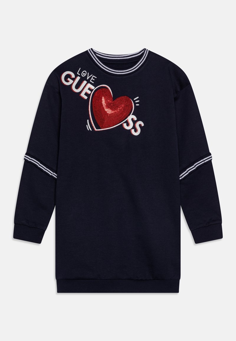 Granatowy sweatshirt posiada okrągły dekolt, paskowane mankiety oraz czerwoną, cekinową grafikę serca z białym napisem "LOVE GUESS". Miękka tekstura materiału.