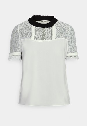 Blouse blanche avec manches courtes en dentelle transparente et poitrine supérieure, col noir à volants, et bordure en dentelle sur les manches.