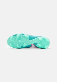 Zapatilla deportiva futurista con parte superior de malla en colores turquesa y rosa, que presenta una suela de goma texturizada con clavos hexagonales para mayor tracción.