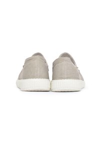 Zapatillas de lona grises con suela texturizada, que presentan un diseño de perfil bajo, parte trasera redondeada y detalle elástico cerca de la abertura.