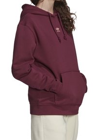 Bordeaux hoodie av bomullsmix, med en framficka, justerbar snörning i huvan och broderad logga på bröstet.
