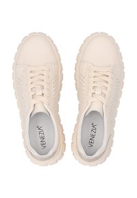 Zapatillas perforadas beige con textura suave, punta redonda y suela blanca gruesa. Presentan cordones planos y una plantilla acolchada.