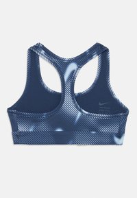 Mornarska športna modrček z dirkaškim hrbtom, ki ima dinamičen modro-beli črtast vzorec. Narejen je iz materiala, ki odvaja vlago.