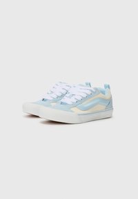 Blue and cream sneakers with a suede and fabric upper, white laces, and a rubber sole. Features side stripe design and heel tab.