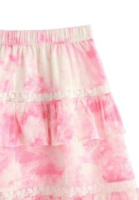 Gonna leggera rosa con effetto tie-dye, dotata di strati di volant e dettagli floreali ricamati. Include una cintura elastica per il massimo comfort.
