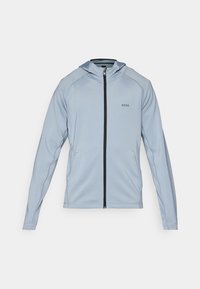 Haut de hoodie zippé bleu clair en tissu doux. Comprend une fermeture éclair à l'avant, des poches latérales et un accent noir sur la fermeture éclair. Logo sur la poitrine.