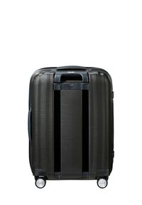 Black hard-shell suitcase with vertical line texture, retractable handle, and four wheels. Features a mid-size design for travel convenience.