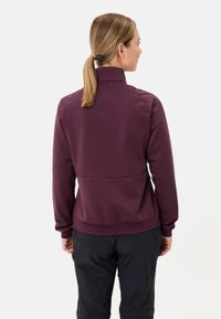 Giacca sportiva bordeaux con colletto alto, polsini a coste e design aderente, realizzata in materiale morbido e elastico.