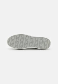 Sole di sneakers grigia con motivo testurizzato e logo in rilievo. Presenta un bordo esterno bianco e la marcatura della taglia "37". La superficie è liscia e gommoso.