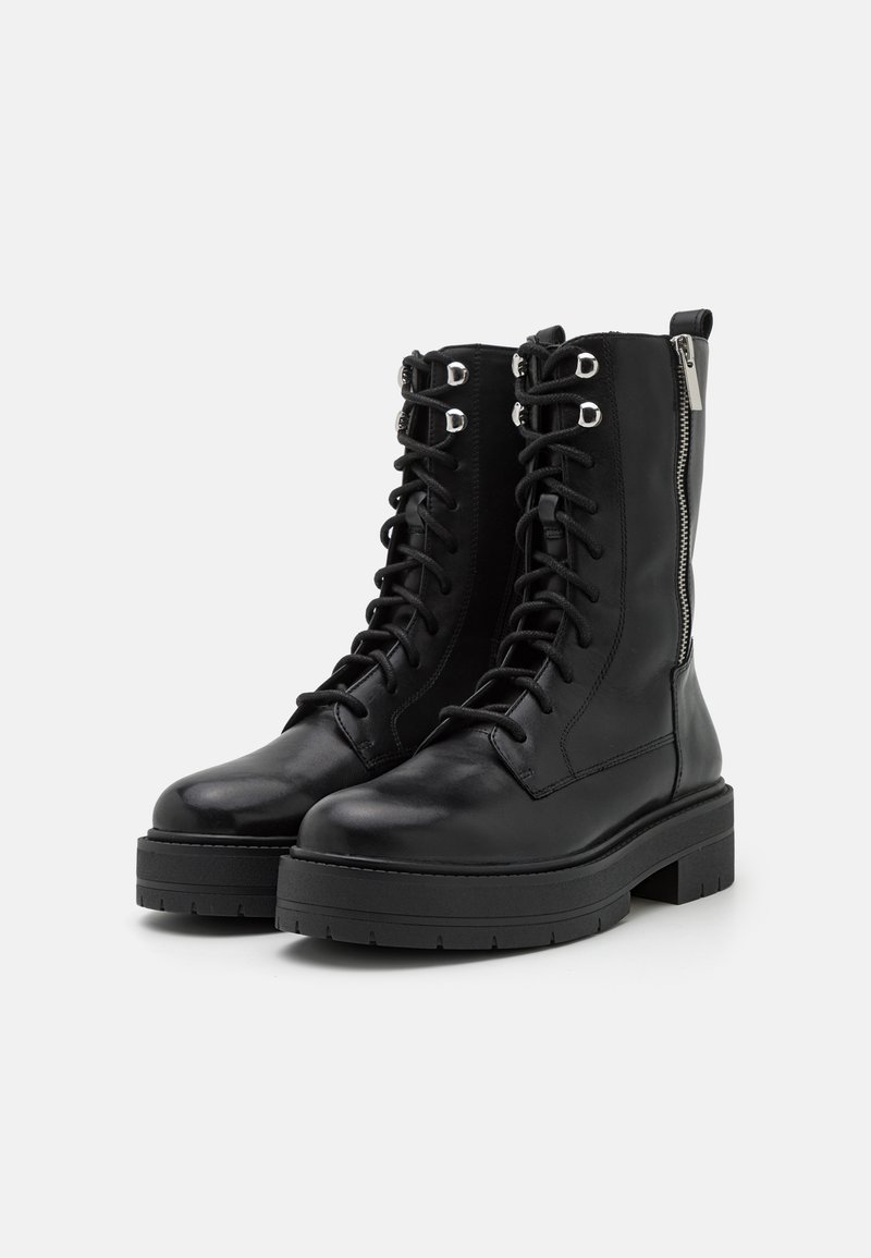 Czarne, sznurowane buty wojskowe mają gładką skórzaną cholewkę, srebrne akcenty, boczny zamek błyskawiczny oraz masywną czarną gumową podeszwę.