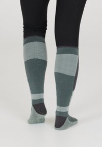 Polvisukkarit, joissa on raidoitus vihreän ja tumman harmaan sävyissä, valmistettu teksturoidusta neuloksesta.