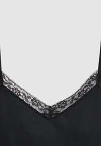 Vêtement en tissu noir avec un col en V bordé de délicats détails en dentelle florale noire.