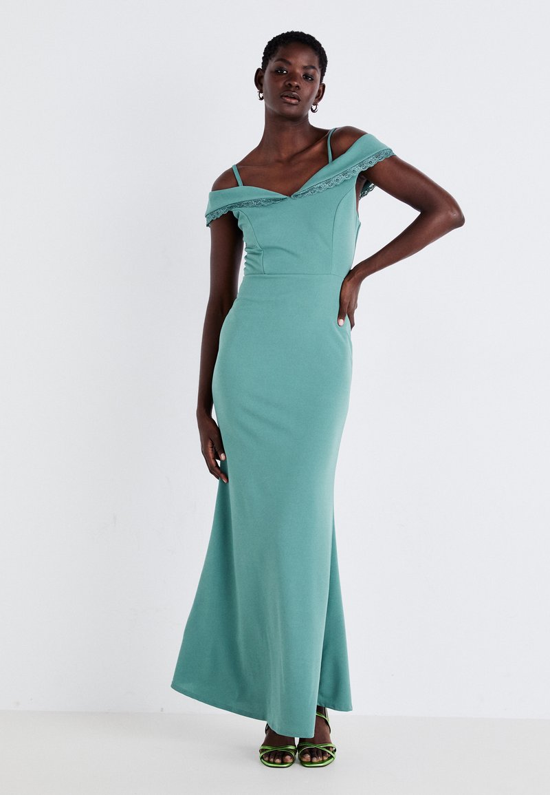 Rochie maxi teal, cu umerii goi, cu dantelă la margine, cu corset ajustat și fustă evazată. Include bretele subțiri și este fabricată dintr-un material elastic.