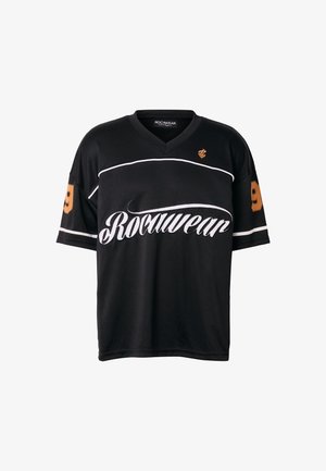 Fekete Rocawear rövid ujjú ing fehér logófelirattal a mellkason, fehér csíkkal és narancssárga 9-es számmal az ujjakon.
